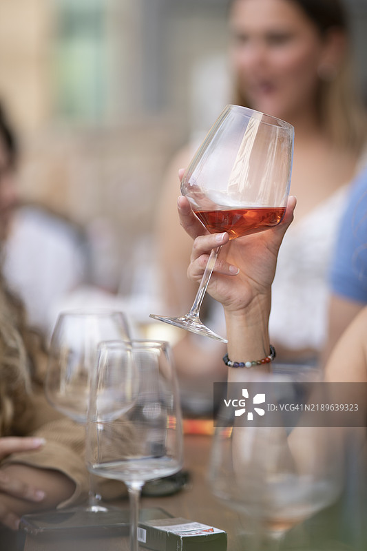 在餐厅里坐着的女人手里拿着酒杯，美国图片素材