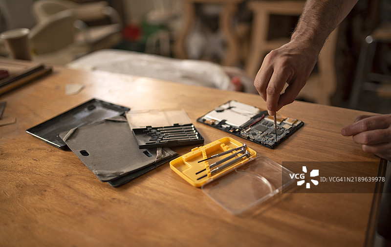 在工作台上修理平板电脑的手图片素材