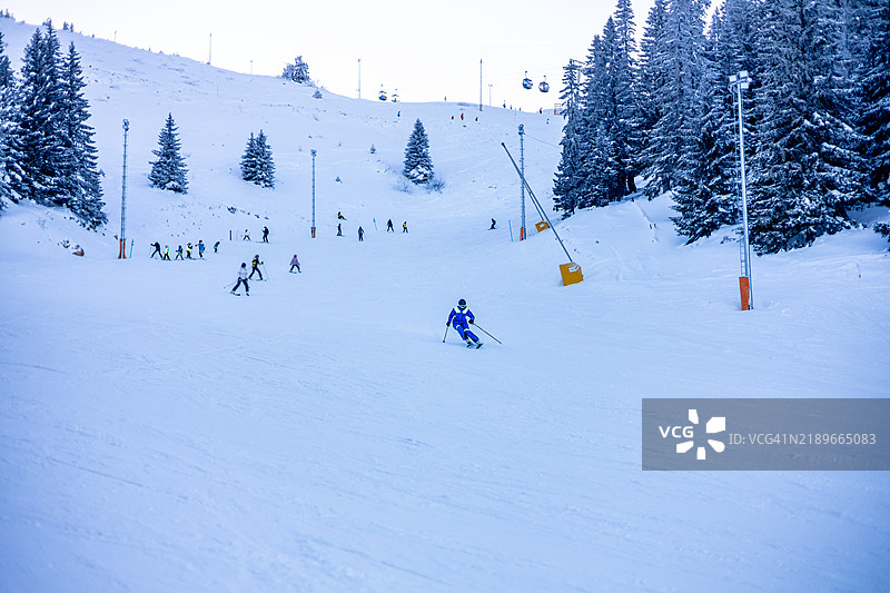 年轻女性在雪山坡上优雅地滑雪图片素材