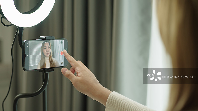女性网红正在录制自己的视频。图片素材