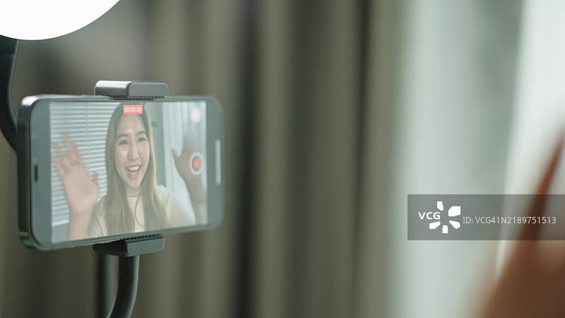 女性网红正在录制自己的视频。图片素材