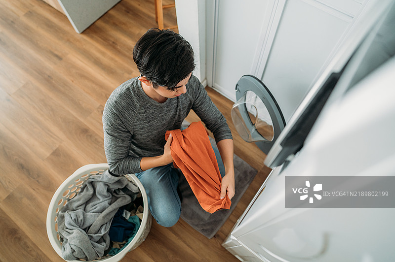洗衣日：一位年轻的中国男子在家中图片素材