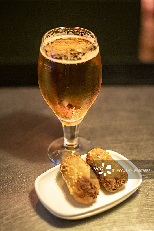 一杯生啤酒和面包裹的马苏里拉奶酪条图片素材