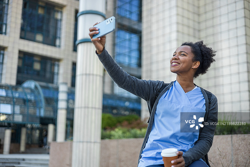 一名医务工作者在诊所外使用手机进行视频通话。图片素材