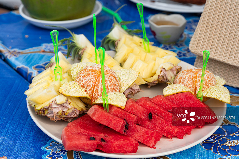 新鲜切好的西瓜、菠萝和橙子片的盘子图片素材