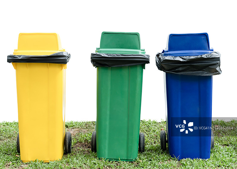 五颜六色的塑料箱子放在草地上，背景为白色，带有抠图路径。图片素材
