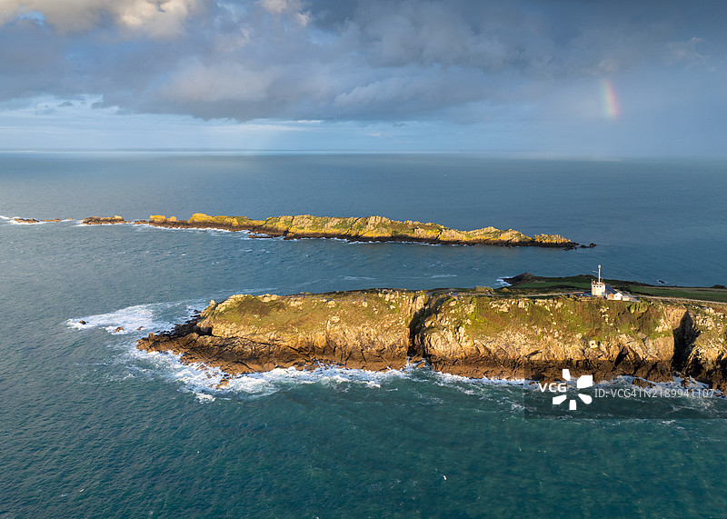 在下雨的天空下，日落时分的康卡尔格鲁安角与彩虹 - 空中视角图片素材
