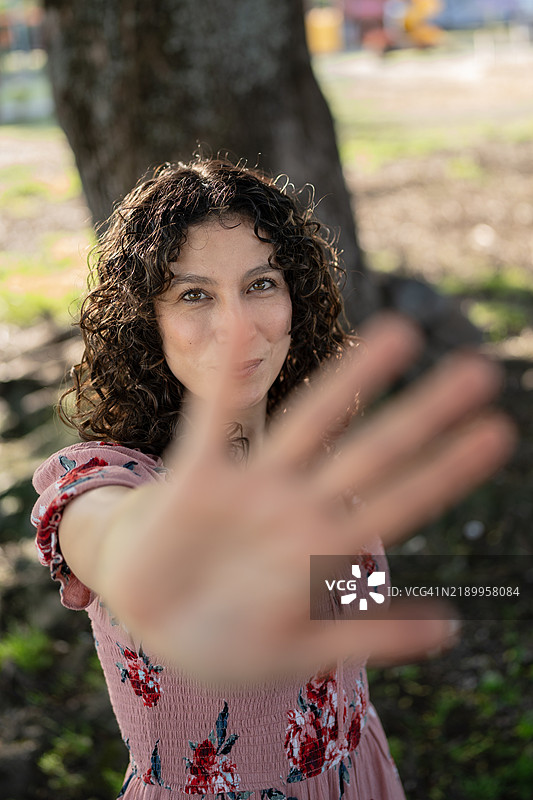 年轻女性在公园里用手做出停止的手势图片素材