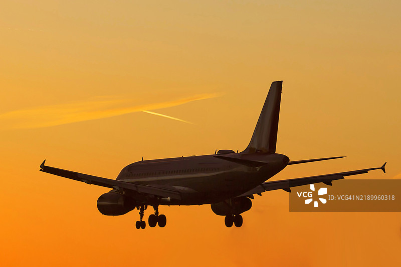 日落时分降落飞机的剪影图片素材