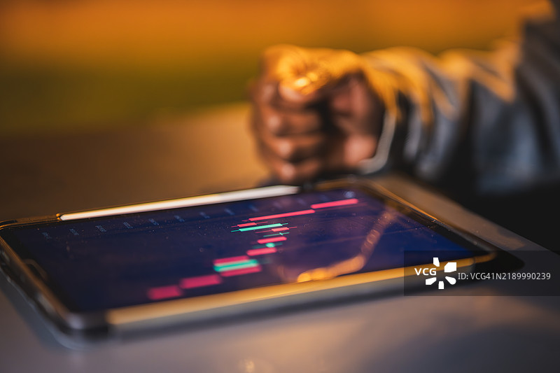 厄瓜多尔商人在夜间用平板电脑分析股市数据图片素材