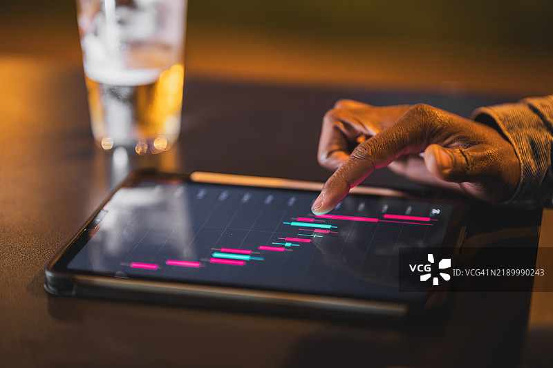 商人在晚上使用数字平板分析财务图表图片素材