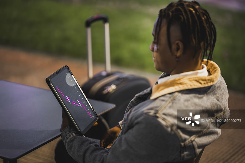 年轻商人在旅行时使用平板电脑分析图表图片素材