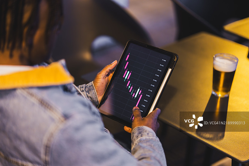 商人在酒吧用平板电脑分析股市数据图片素材