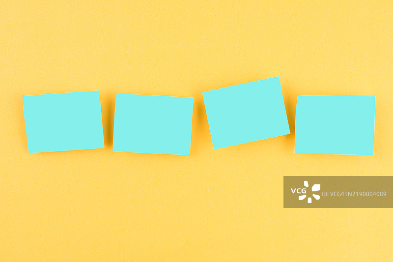 蓝色空白便签纸在黄色背景上。图片素材