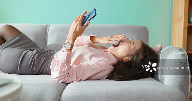 亚洲女商人躺在沙发上图片素材