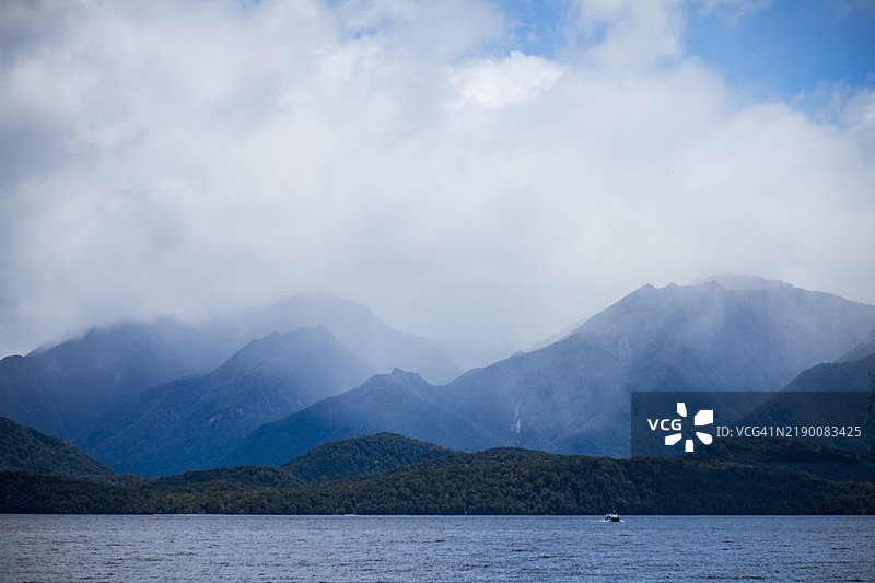 被云层覆盖的山脉环绕的峡湾，位于菲ordland国家公园图片素材