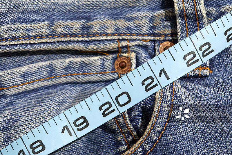 牛仔裤上的卷尺特写图片素材