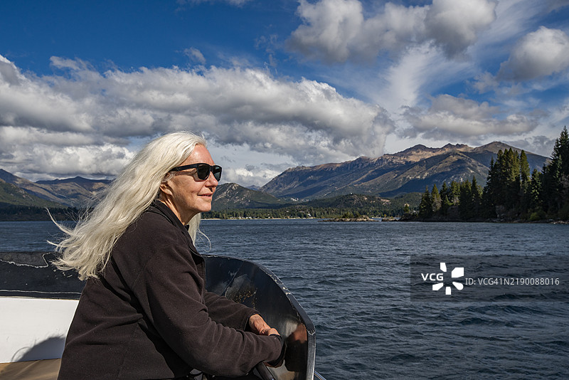 长发白发的女人在纳韦尔瓦皮湖上的船上图片素材