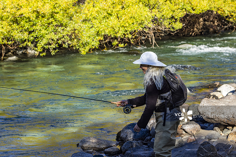 戴白色帽子的女性在特拉富尔河钓鱼图片素材