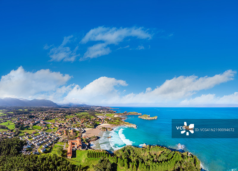 西班牙阿斯图里亚斯的塞洛里奥村庄天际线和海滩的无人机航拍视图图片素材