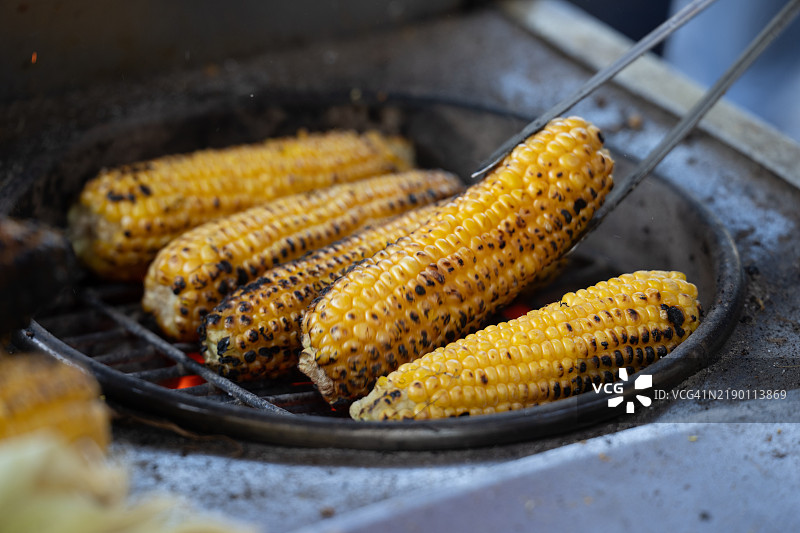烤制街头玉米的烹饪过程。图片素材