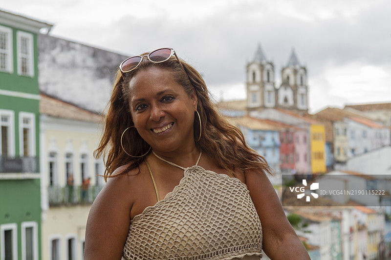 一位快乐美丽的巴西非洲裔成熟背包客女性在巴西巴伊亚州萨尔瓦多的历史街区佩洛里尼奥享受她的退休生活。图片素材