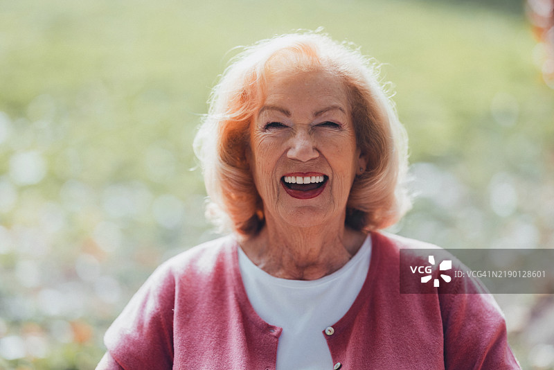 快乐的老年女性在阳光明媚的户外微笑图片素材