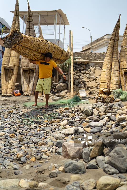 渔夫将芦苇船搬到岸边图片素材