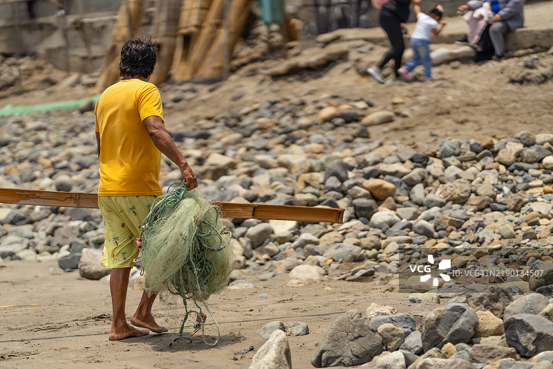 渔民从海里提着渔网图片素材