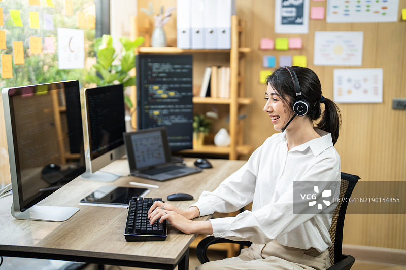 专注的女性程序员在现代办公室环境中使用电脑图片素材