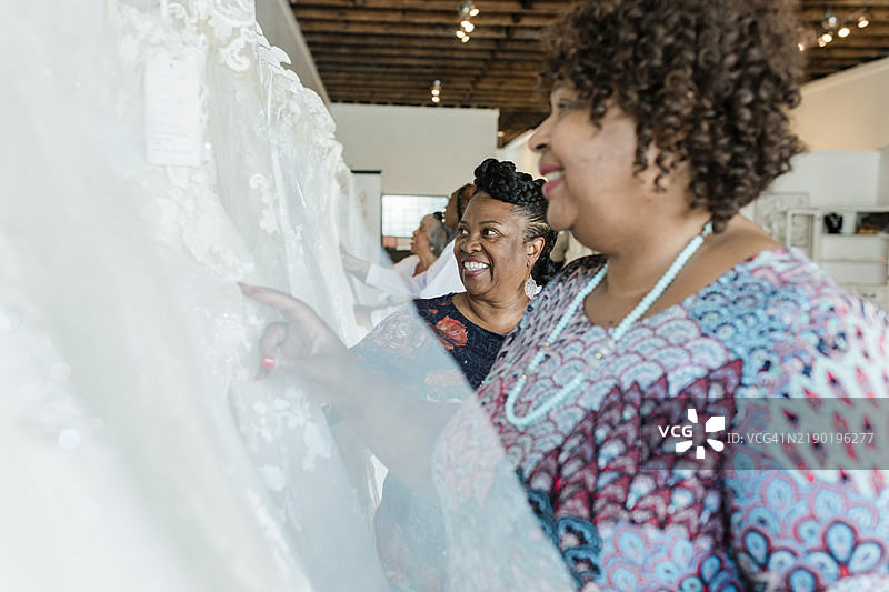两位年长女性微笑着看婚纱图片素材