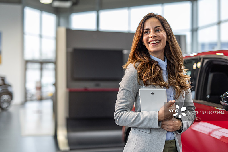 专业汽车销售顾问站在汽车经销商处图片素材