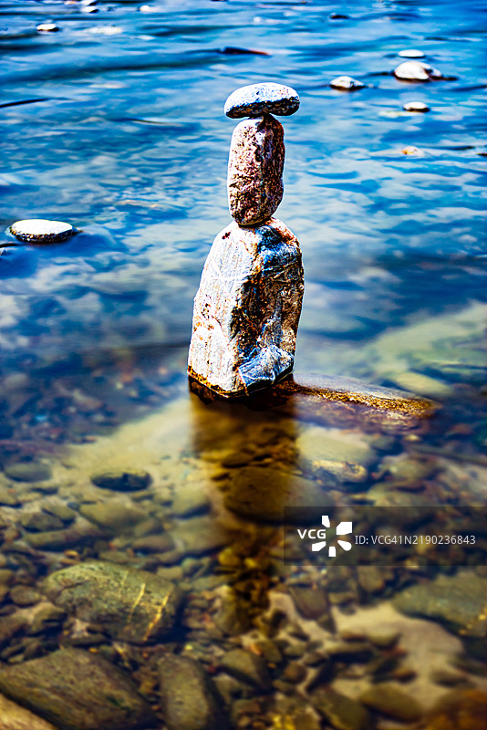 河中间看起来像雕像的宁静石头平衡图片素材