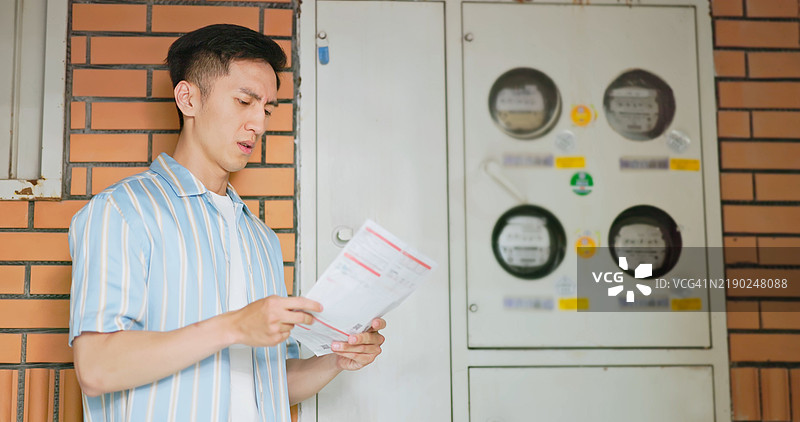 亚洲男子对浪费电力感到不满图片素材