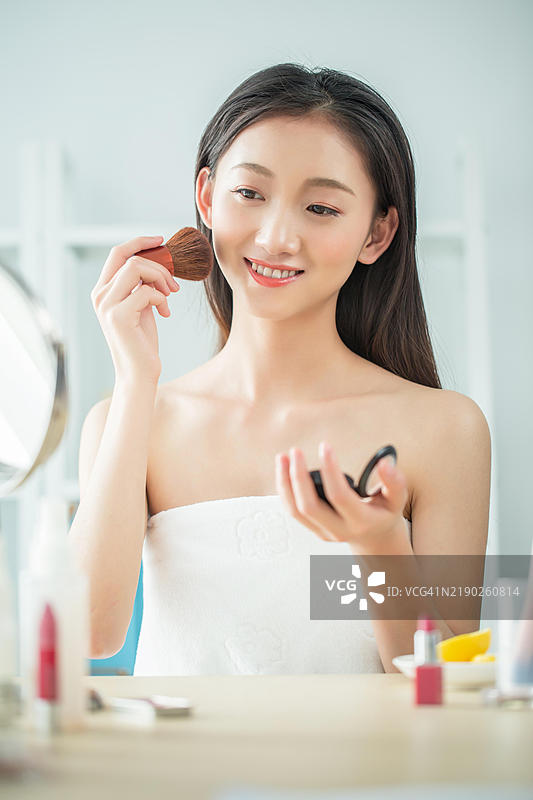 亚洲女性在脸上涂腮红图片素材