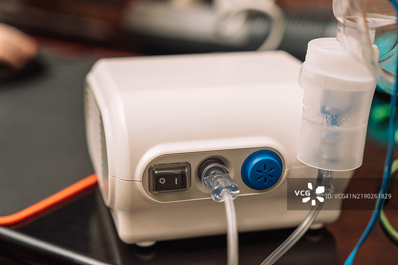 雾化器放在桌子上，旁边有个孩子图片素材