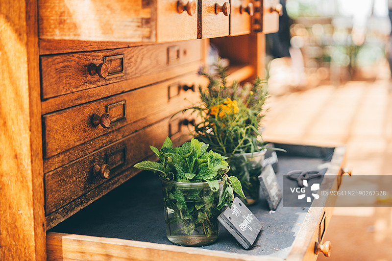 装满新鲜采摘的草药（包括薰衣草和薄荷）的木制药剂盒正在展出出售。这幅乡村静物画捕捉了农产品、草药学和古代植物市场的有机之美。图片素材