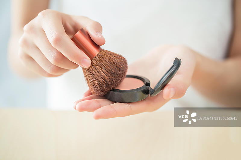 用刷子涂抹腮红图片素材