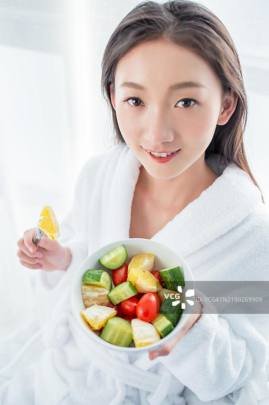 亚洲女性在床上吃沙拉图片素材