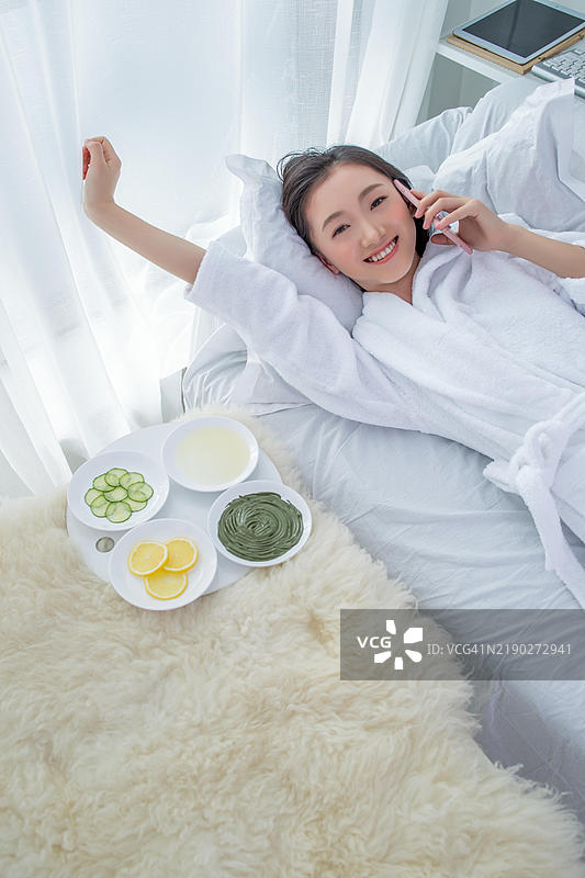 一位女性在接受水疗护理时打电话。图片素材