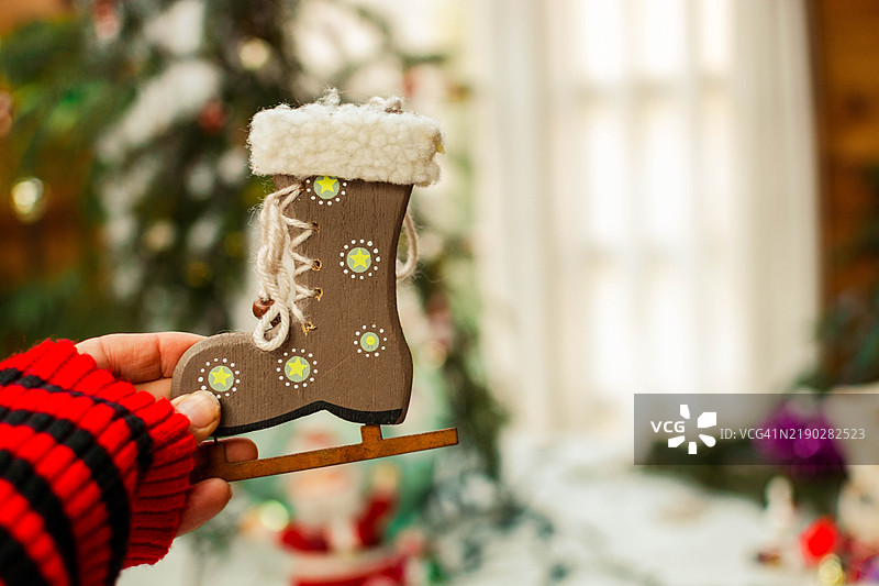 手中拿着乡村风格的木靴，圣诞细节。图片素材