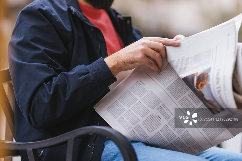 男人在户外以放松的姿势阅读报纸图片素材