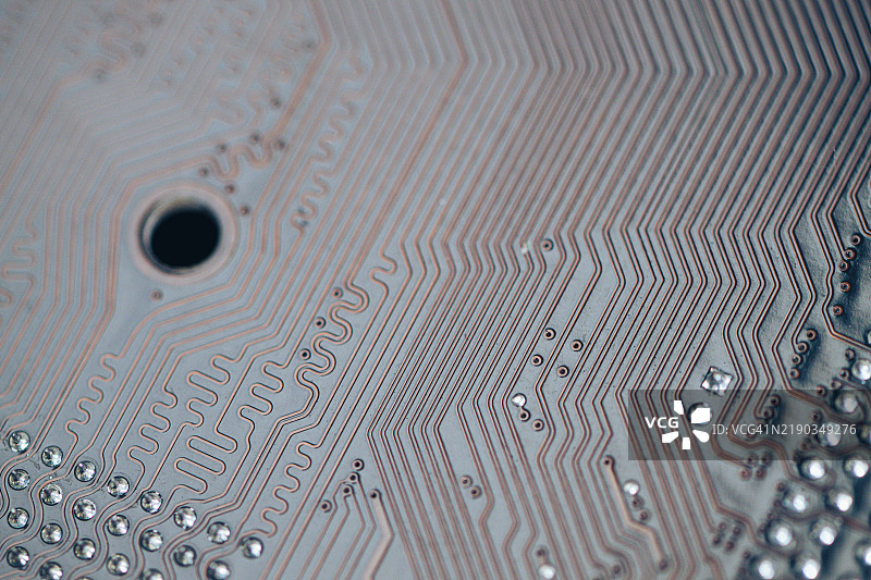 电路板复杂图案的详细视图，展示了细线、通路和电子元件。图片素材
