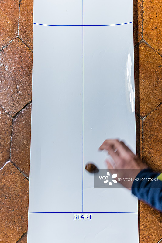 男孩在玩桌面冰壶游戏图片素材