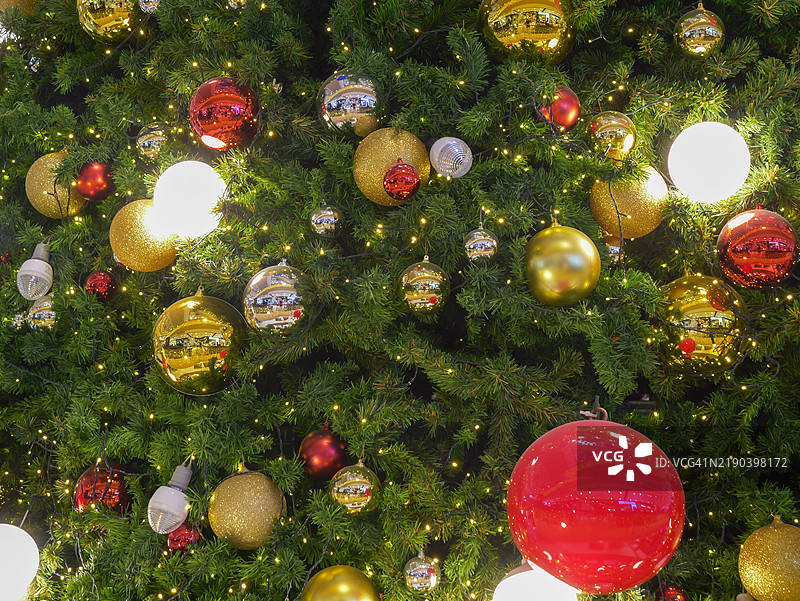 纽约圣诞树装饰 - 精灵串灯、假雪、亮片和五彩缤纷的装饰品装点着树枝。图片素材