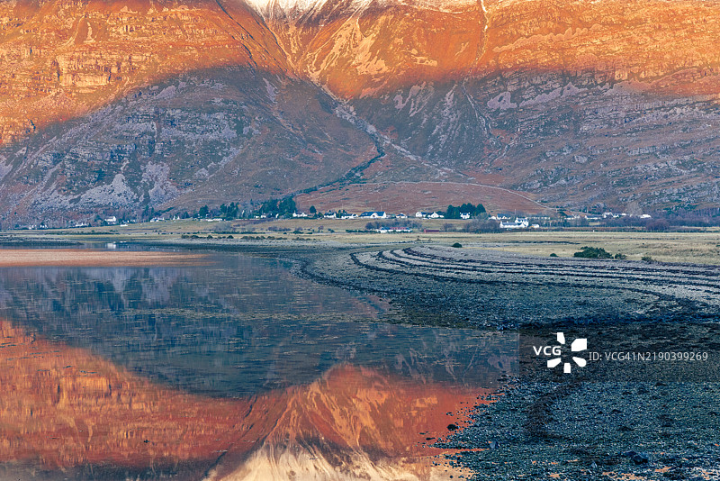 托里登村位于利亚塔赫山脚下，映照在托里登湖的水面上，苏格兰高地。温暖的冬日阳光照亮了山坡。图片素材