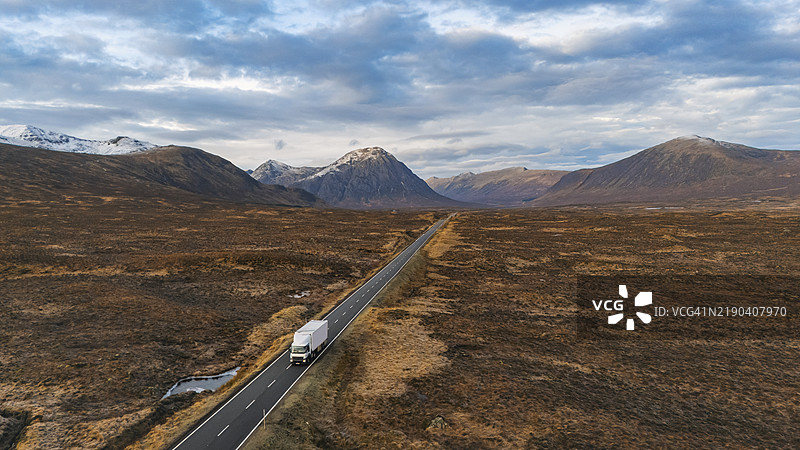 冬季早晨，苏格兰格伦科谷（Glencoe Valley）A82公路上的卡车航拍视角图片素材
