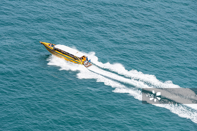 在泰国，游客们乘坐快艇在碧绿的海水中游览图片素材