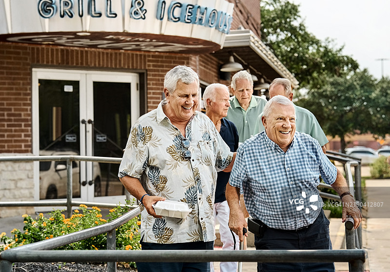 一群老年朋友拿着外卖食物走出餐厅图片素材