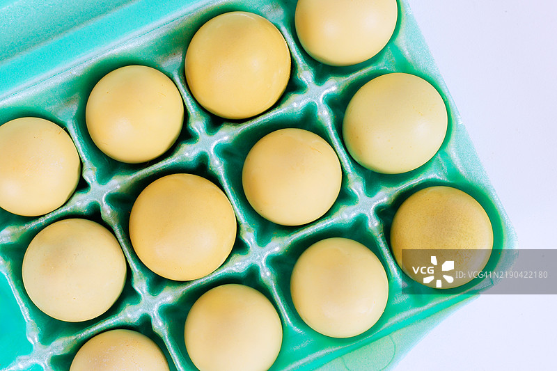 整齐的蛋 carton，十二个黄色鸡蛋被整齐地排列好，准备使用。图片素材